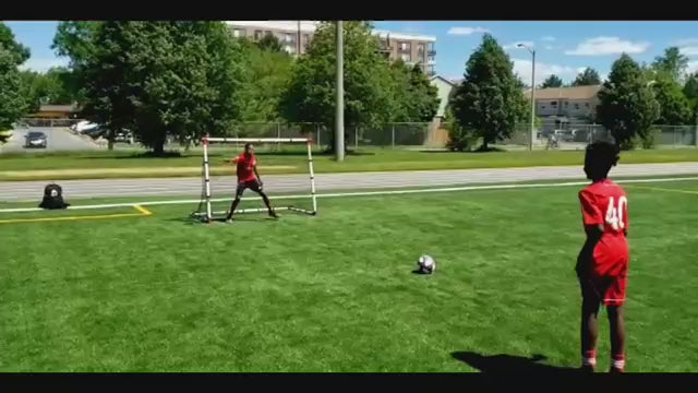 Load video: Two boys playing soccer with their Eznet in a park, demonstrating its ease of transport.